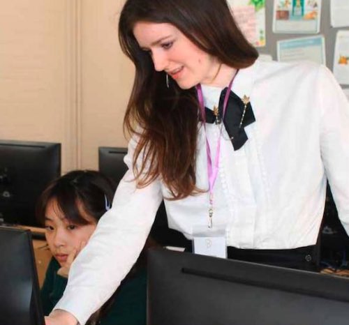 helping a girl at a coding workshop. image belongs to Downe House School.